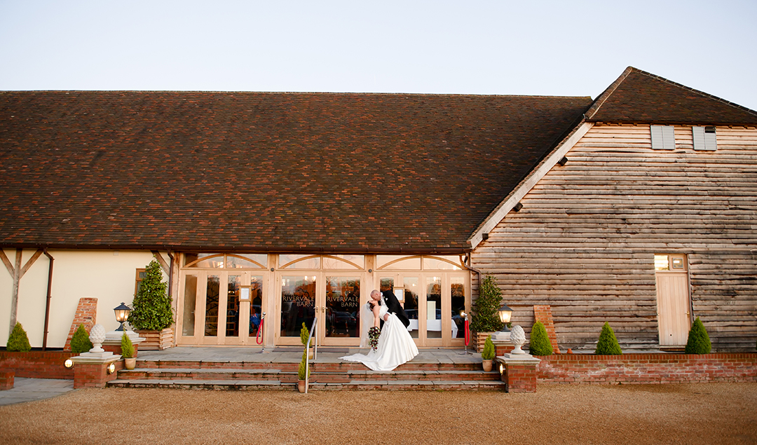 The newlyweds shared a kiss on the steps of this exquisite Hampshire barn wedding venue
