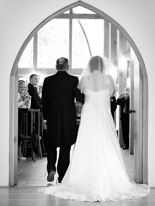 The bride and her father walk down the aisle into the beautiful Ceremony Barn at one of hampshire’s most breathtaking venues