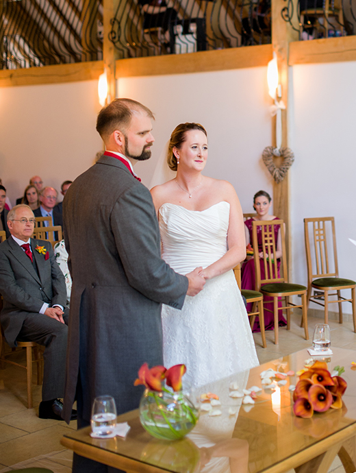 The bride and groom stood hand in hand during their ceremony at the magical Rivervale Barn in Hampshire