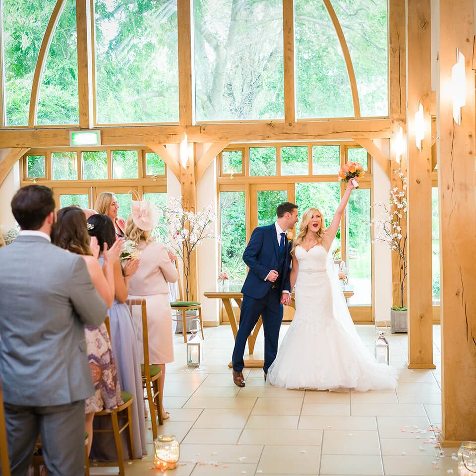 The bride and groom celebrate their wedding ceremony at this gorgeous barn wedding venue in Hampshire
