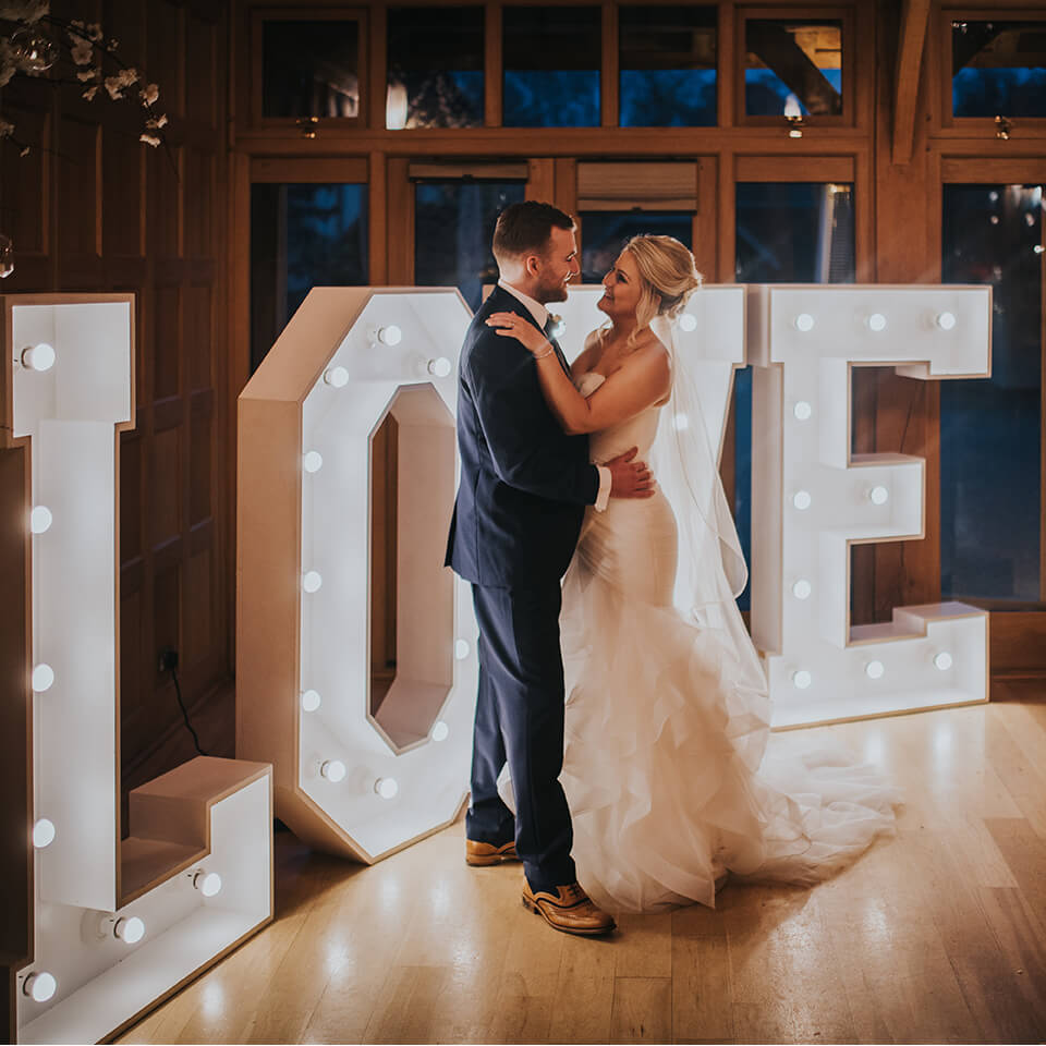 Michelle and Chris took a moment in front of the love letters at one of Hampshire's most beautiful wedding venues