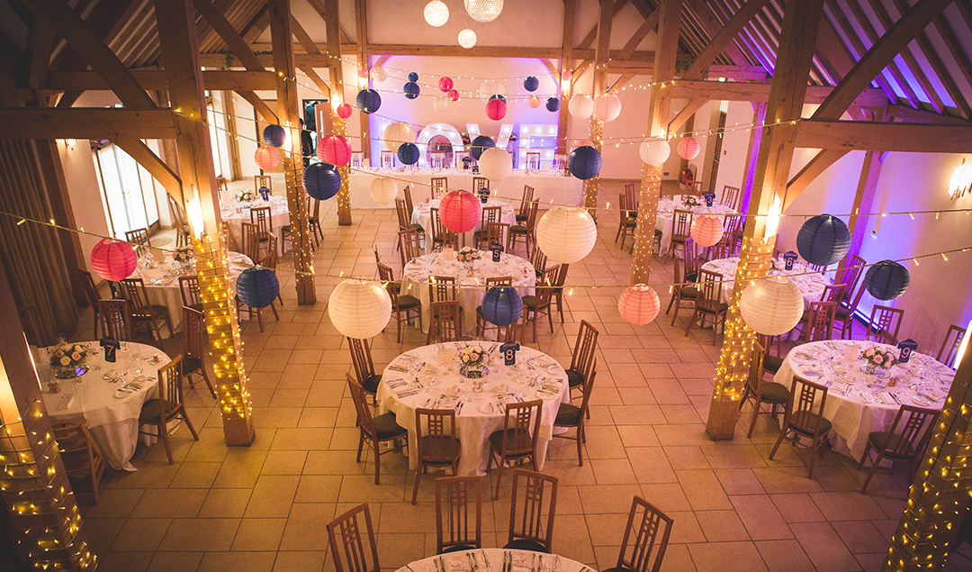 The beautiful Reception Barn is set up for the wedding breakfast and decorated with paper lanterns