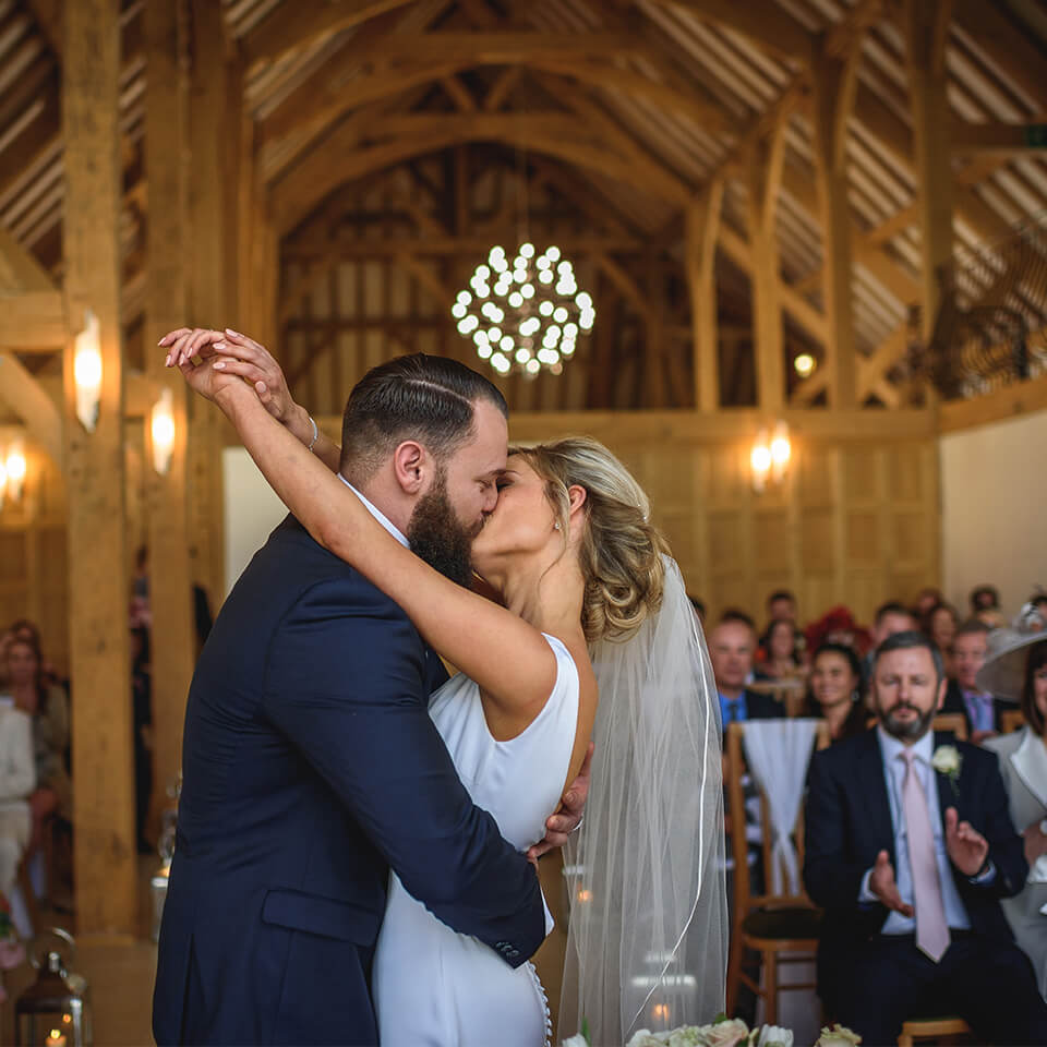 The bride and groom share a kiss in front of family and friends during their spring wedding