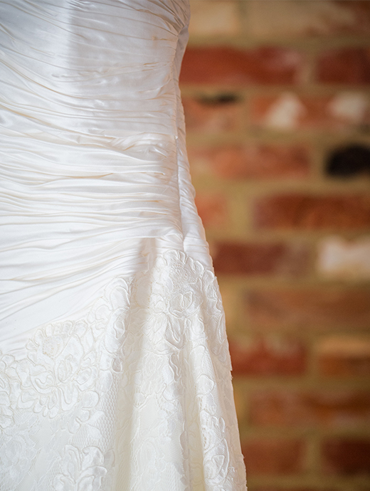 A close up look of the delicate detail on the bride’s gorgeous wedding dress