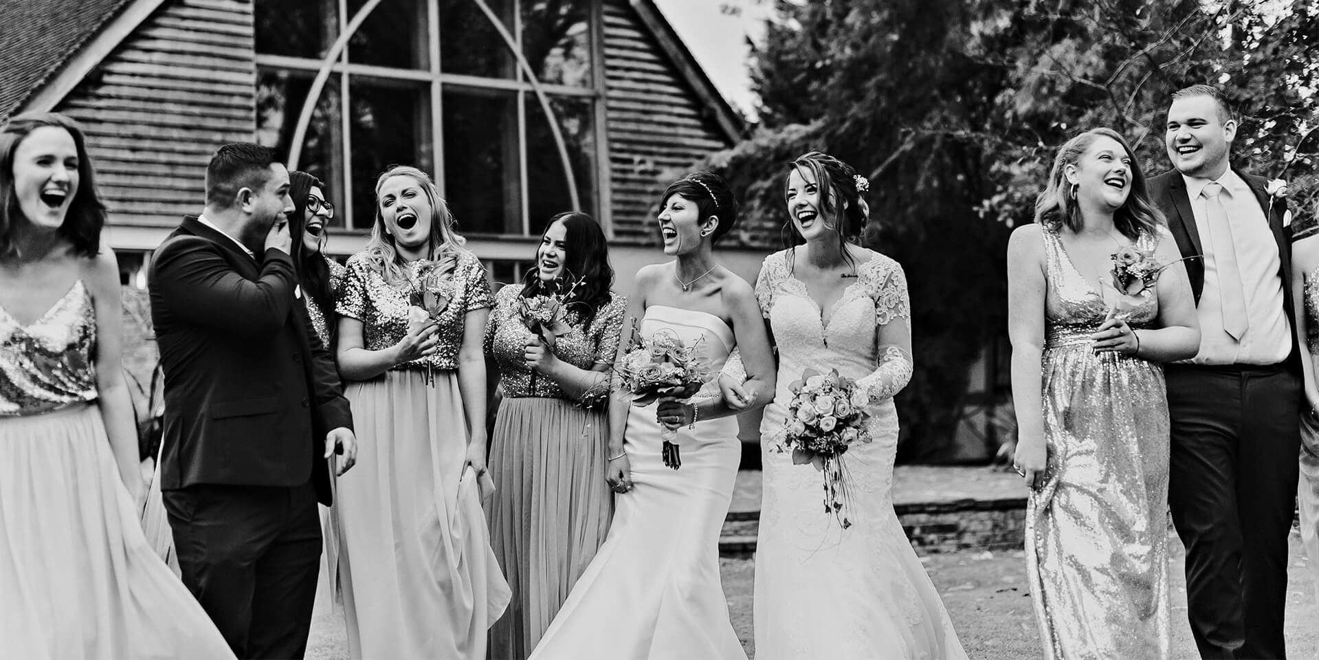 The wedding party joke around outside this stunning barn wedding venue in Hampshire