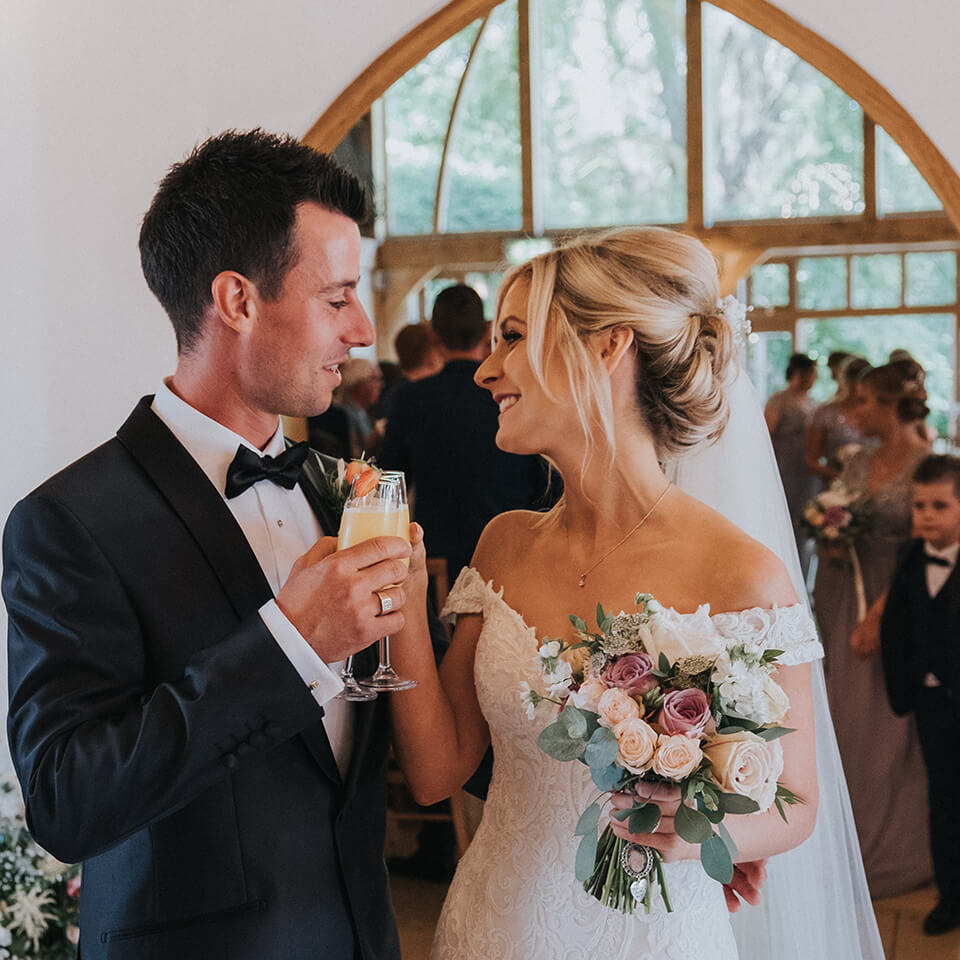 The newly married couple raise a glass to the wedding ceremony at their beautiful barn wedding venue