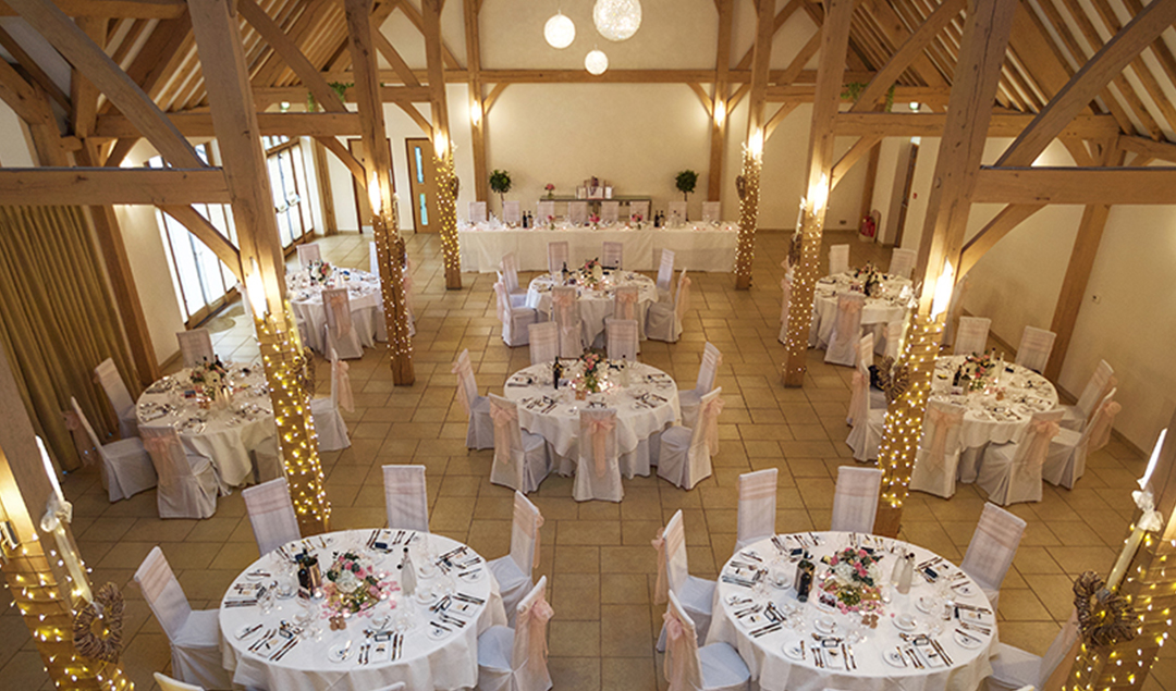 Plenty of fairy lights and show stopping table decorations dress the beautiful Reception Barn at Rivervale Barn
