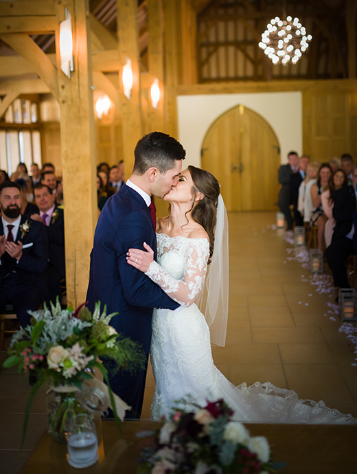 The bride and groom share a kiss in front of family and friends at this picture perfect Hampshire wedding venue