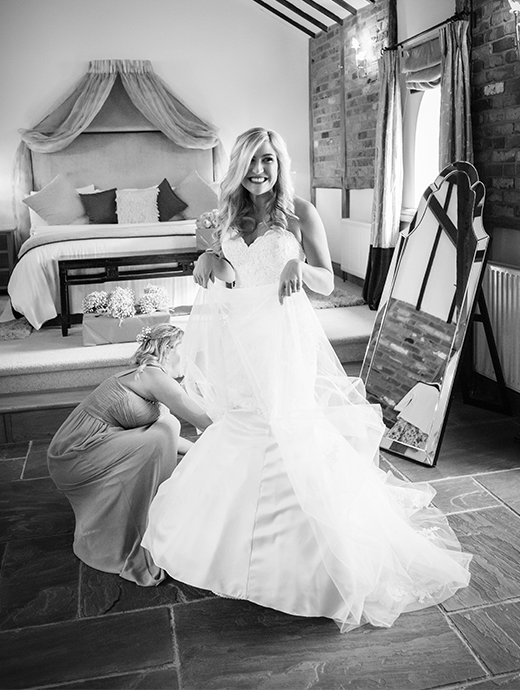 The bride doing her final preparations to make sure her dress is perfect ready for the wedding ceremony