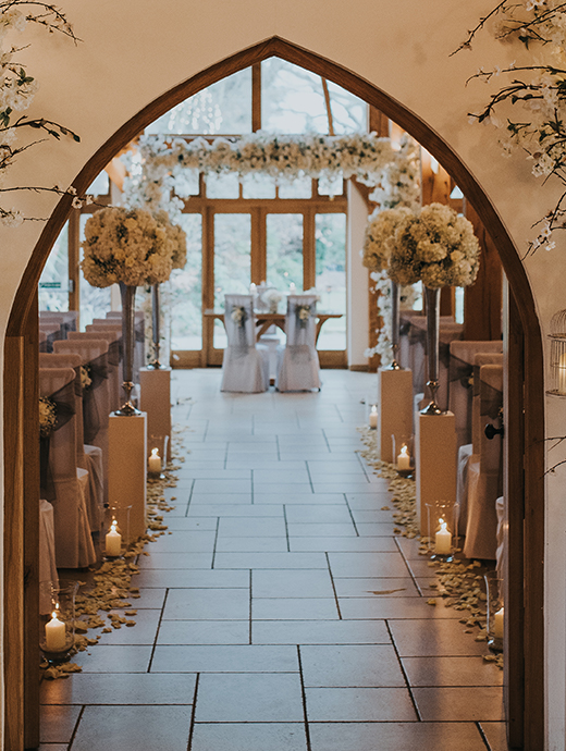 The ceremony barn was dressed in white florals and candles making a romantic entrance for the bride