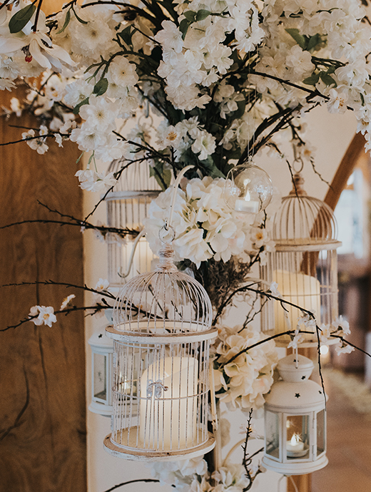 white flowers, birdcages and lanterns made beautiful focal points at this stunning Hampshire barn wedding venue