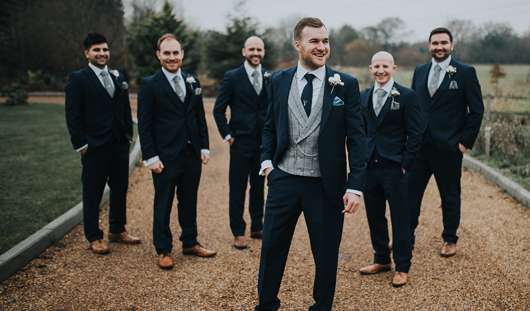 the groom and his party posed outside before the celebrations at this beautiful Hampshire barn wedding venue