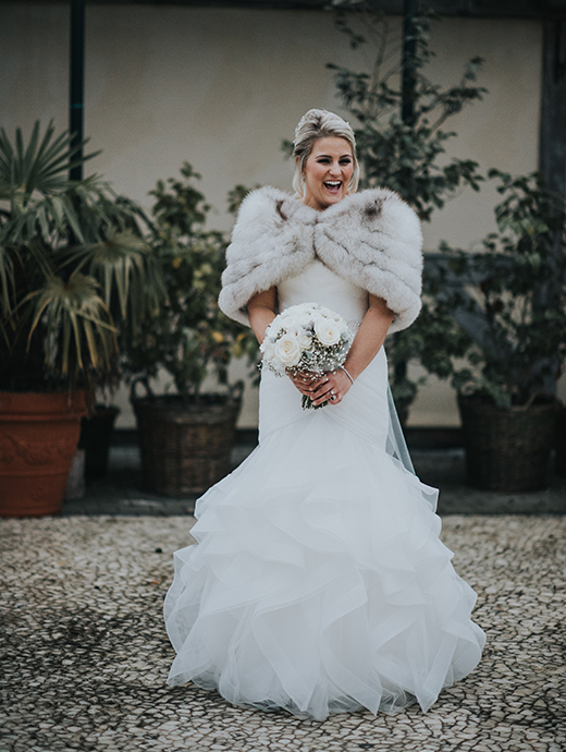 The bride wore a stunning white dress with a fur shawl to keep her warm yet elegant during her winter wedding