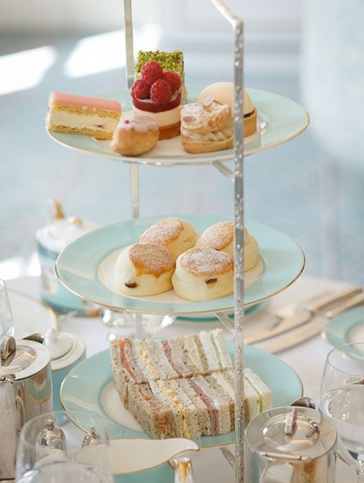 A delicious afternoon tea serving with cream cakes, scones and sandwiches