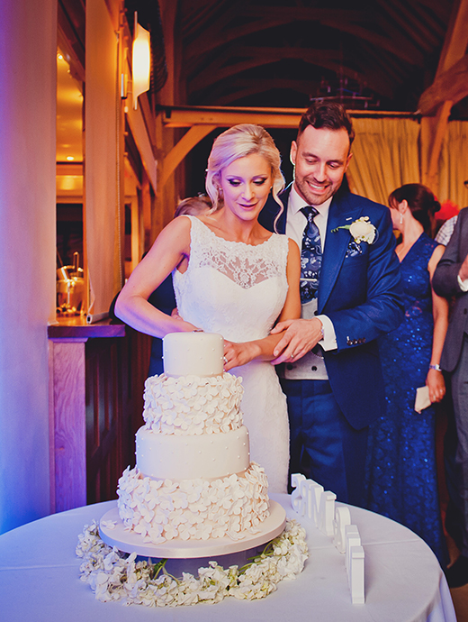 The bride and groom sliced into the beautiful white wedding cake together