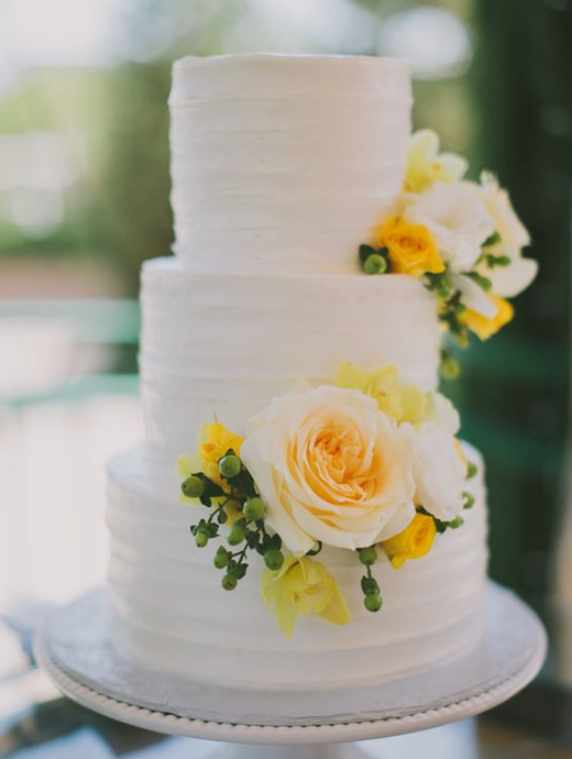 a beautiful wedding cake decorate with big yellow flowers, great for a summer wedding