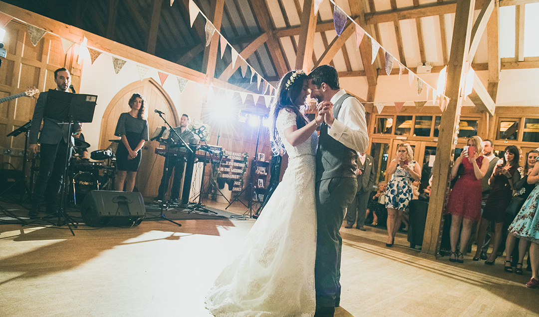 the bride and groom enjoyed their first dance in front of friends and family
