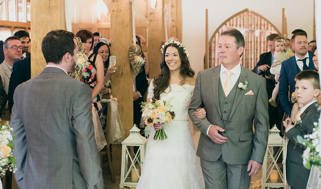 the bride being walked down the aisle by her father at this beautiful Hampshire venue