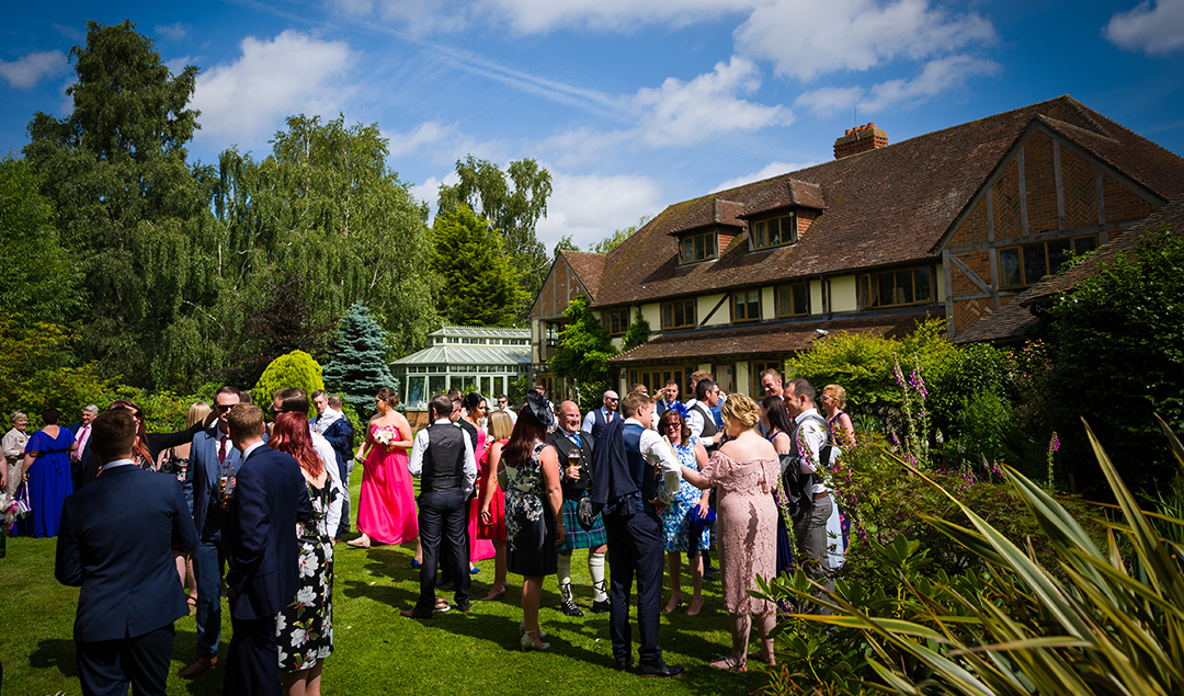 guests enjoying the drinks reception in Rivervale Barn’s beautiful gardens