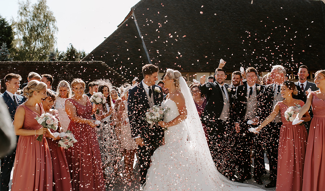 Guests throw confetti at newlyweds after the wedding ceremony